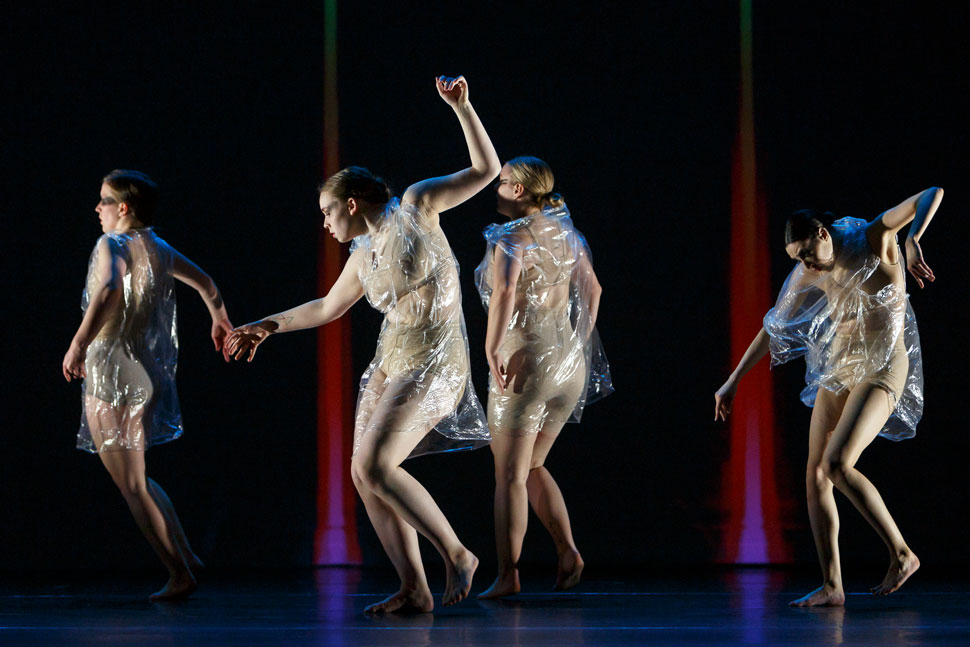 4 dancers wear clear plastic outfits as they dance in IM•MORTAL