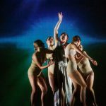 5 dancers pose in front of a burst projection in IM•MORTAL
