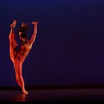A dancer does a high kick in Theta Waves