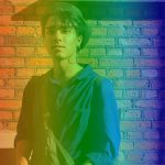 York Design student Jai Bhatia stands in front of a brick wall with a rainbow overlay.